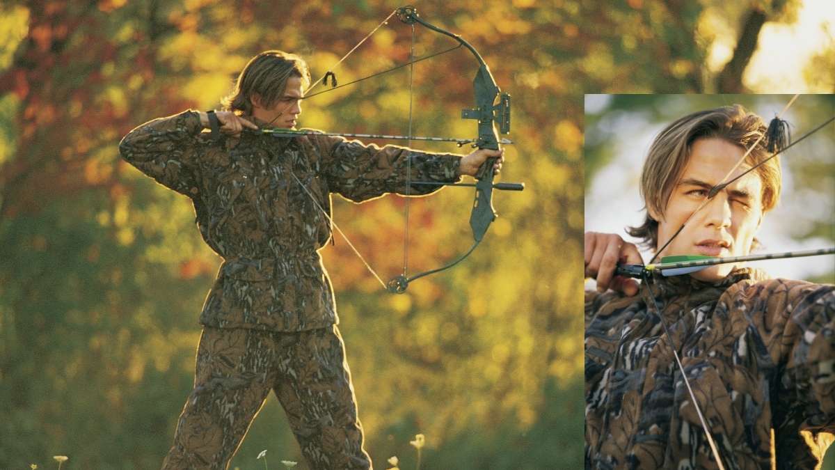 Hunter aiming with camouflage compound hunting bow with arrow