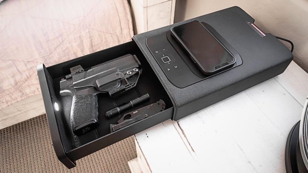 nightstand gun safe with phone charger lyinh on table
